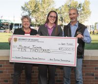 Three veterinarians hold a large cheque